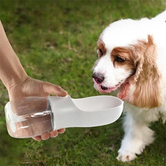 Portable pet travel water bottle for dogs and cats, featuring easy-pour drinking bowl, used outdoors by a dog.