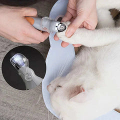 Professional pet nail clippers with LED light in use on a cat's paw.