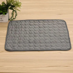 Cooling silk kennel pad for cats and dogs on a wooden floor.