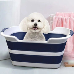 Folding pet bath tub with drainage hole and white dog inside.