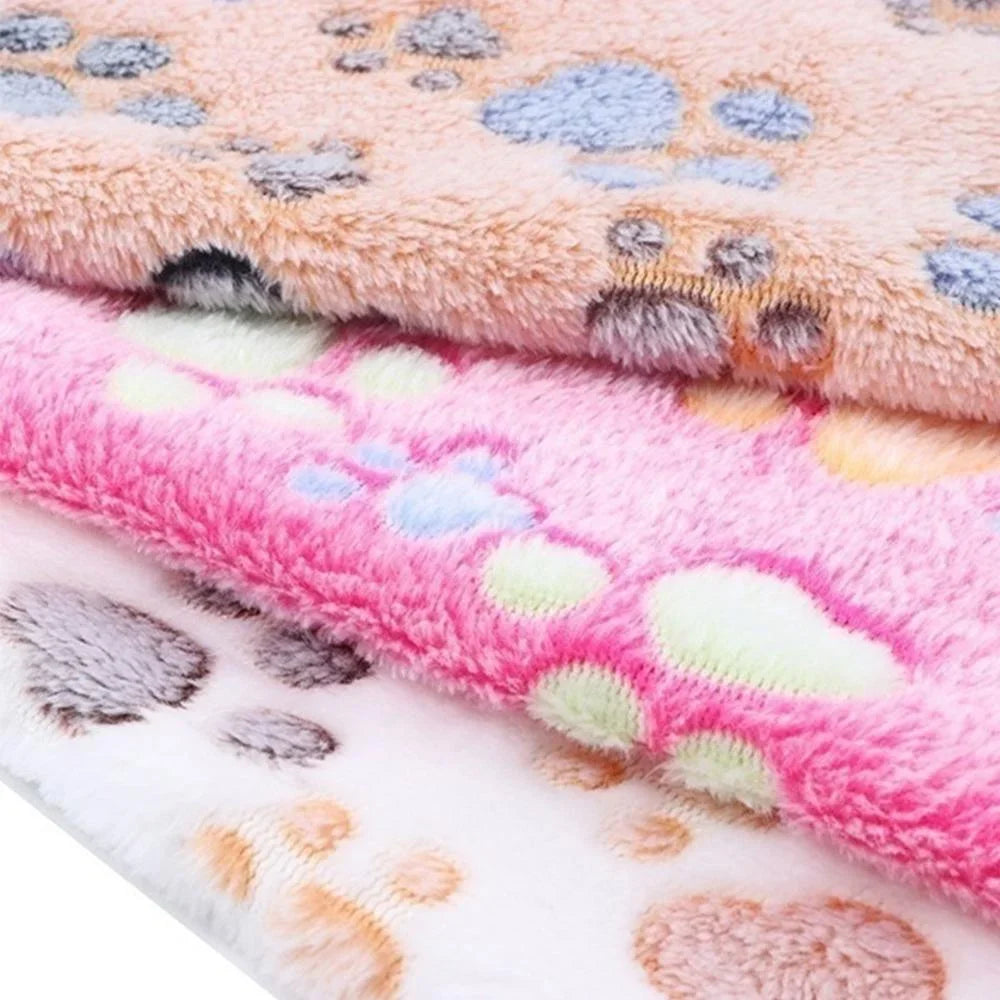Soft fluffy cartoon pet blanket with paw designs in pink, beige, and white.