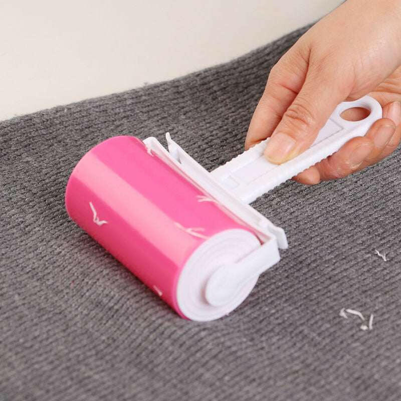 Washable sticky roller for pet hair removal on grey fabric surface.